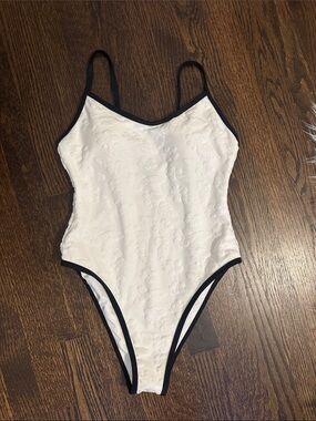 Woman’s white One-Piece Swimsuit with flower details and high leg style